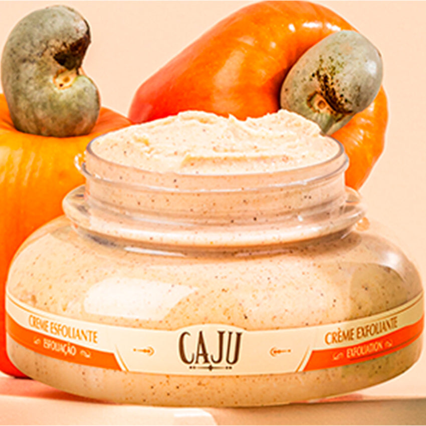 Pote aberto dde Creme Esfoliante Para Corpo L'occitane Caju Creme Esfoliante, com frutas de caju ao fundo.